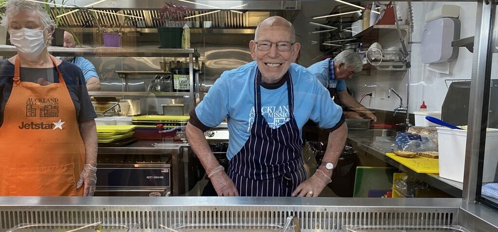 Volunteer Bil smiling from inside the Haeata kitchen.